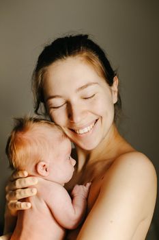 Portrait of caucasian woman holding new born baby. Concept of of mother and her child, little kids and newborns. Selective focus