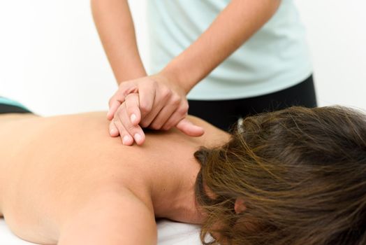 Young woman receiving a back massage in a spa center. Female patient is receiving treatment by professional therapist.