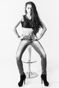 Brunette woman with blue eyes wearing sweater and blue jeans on white background. Studio shoot