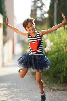 Little girl, eight years old, jumping in an urban park.