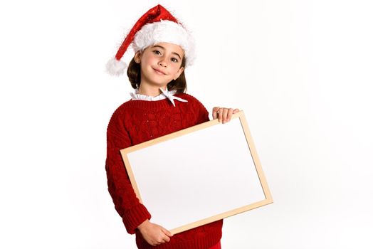 Little girl wearing santa hat holding blank board for advertisementon on white background. Invitation to christmas activities. Winter clothes