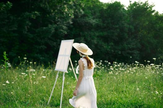 pretty woman in white dress outdoors easel art. High quality photo