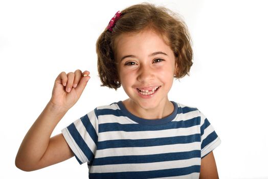 Happy little girl showing her first fallen tooth. Smiling little woman with a incisor in her hand. Isolates on white background. Studio shot.