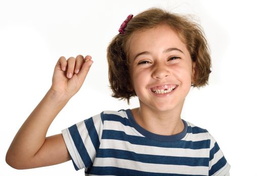 Happy little girl showing her first fallen tooth. Smiling little woman with a incisor in her hand. Isolates on white background. Studio shot.