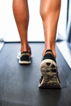 Male muscular legs running on the treadmill at the gym. Concept for fitness, exercising and healthy lifestyle.