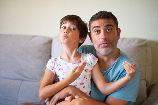 Little cute daughter doing make-up to her father. Dad spending free time with her daughter. Alternative masculinity concept.