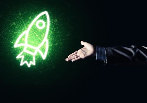 Rocket glowing icon and businessman hand on dark background