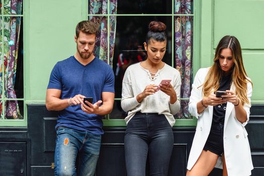 Multiracial group of people looking down at smart phone, concepts about technology addiction and youth