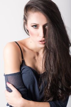 Brunette woman with blue eyes wearing sweater and blue jeans on white background. Studio shoot
