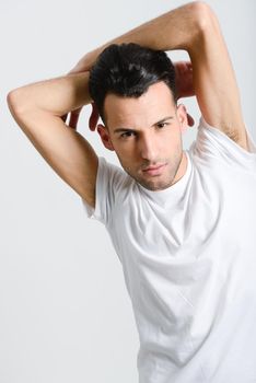 Portrait of a smart serious young man standing against white background