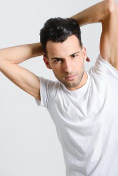 Portrait of a smart serious young man standing against white background
