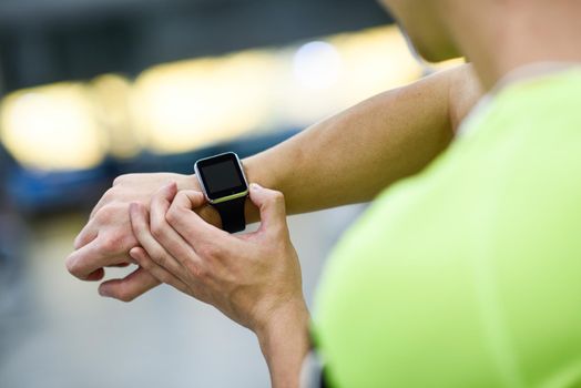 Young man using smartwatch at the gym. Caucasian male working out.