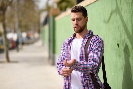 Attractive young man standing in urban background. Guy wearing casual clothes. Lifestyle concept.
