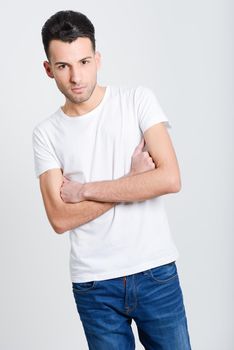 Portrait of a smart serious young man standing against white background