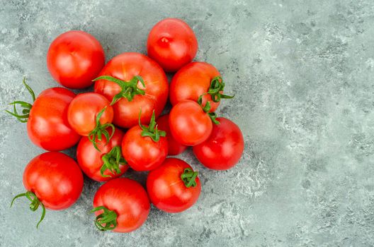 Bunch of ripe tomatoes on blue-gray background. Studio Photo.