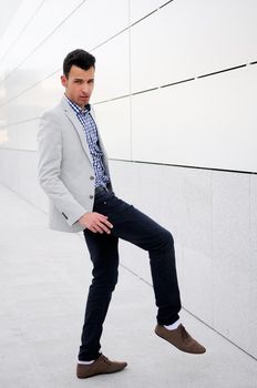 Portrait of a young handsome man, model of fashion, wearing jacket and shirt in urban background