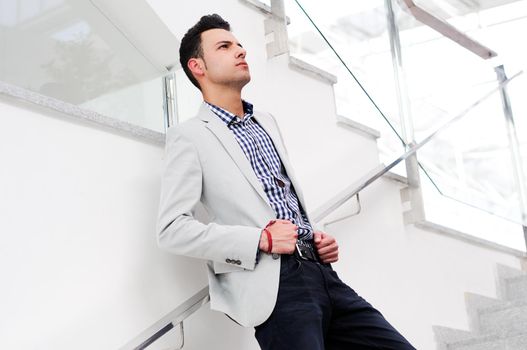 Portrait of a young handsome man, model of fashion, wearing jacket and shirt in urban background