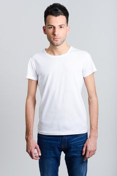 Portrait of a smart serious young man standing against white background