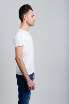 Portrait of a smart serious young man standing against white background