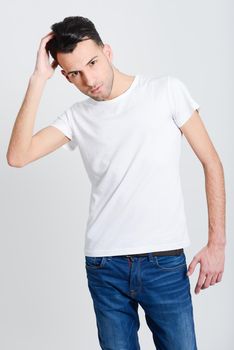 Portrait of a smart serious young man standing against white background