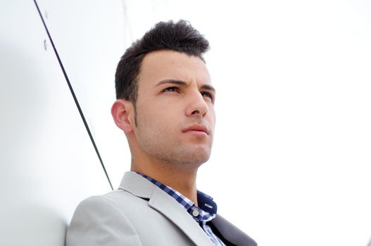 Portrait of a young handsome man, model of fashion, wearing jacket and shirt in urban background