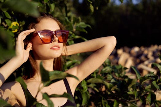 pretty woman wearing sunglasses green leaves glamor posing summer. High quality photo