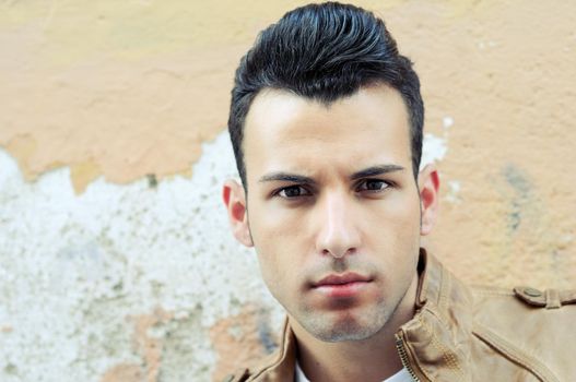 Portrait of a young handsome man, model of fashion, with toupee in urban background