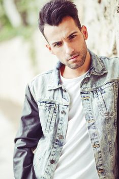 Portrait of a young handsome man, model of fashion, with modern hairstyle in urban background