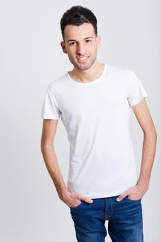 Portrait of a smart smiling young man standing against white background