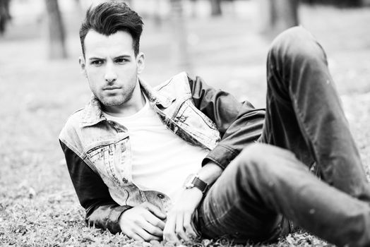 Portrait of a young handsome man, model of fashion, with modern hairstyle in urban background