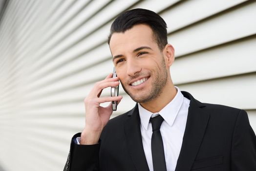 Portrait of an attractive young businessman smiling on the phone in an office building