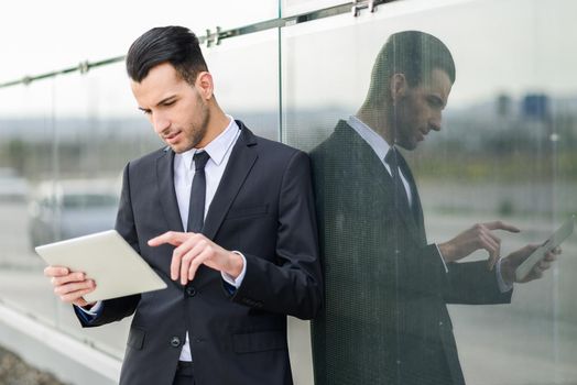 Portrait of attractive young businessman with a tablet computer in an office building