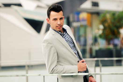 Portrait of a young handsome man, model of fashion, wearing jacket and shirt in urban background