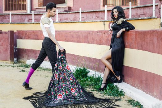 Portrait of a pretty couple, models of fashion, in a bullring. Spanish style