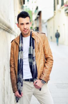 Portrait of a young handsome man, model of fashion, with toupee in urban background