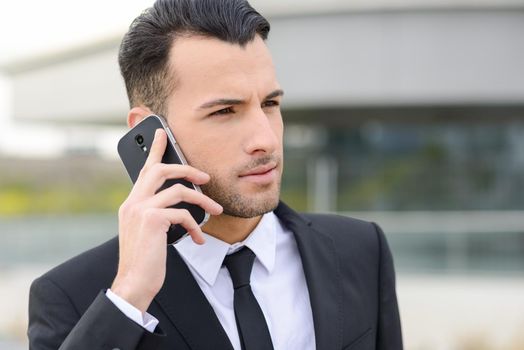 Portrait of an attractive young businessman on the phone in an office building