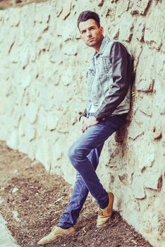 Portrait of a young handsome man, model of fashion, with modern hairstyle in urban background