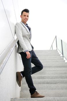 Portrait of a young handsome man, model of fashion, wearing jacket and shirt in urban background