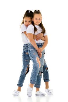 Two cute little girls in full growth, in the studio on a white background. The concept of a happy childhood, Beauty and fashion. Isolated.