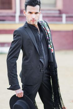 Portrait of a handsome man, model of fashion, wearing spanish clothes in a bullring