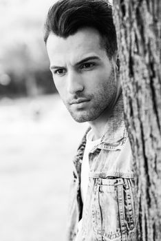 Portrait of a young handsome man, model of fashion, with modern hairstyle in urban background