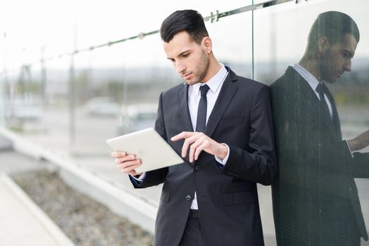 Portrait of attractive young businessman with a tablet computer in an office building