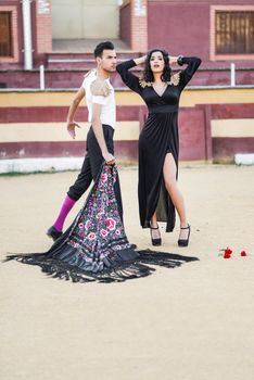 Portrait of a pretty couple, models of fashion, in a bullring. Spanish style