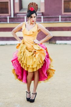 Portrait of a pretty woman, model of fashion, wearing a dress in a bullring. Spanish style