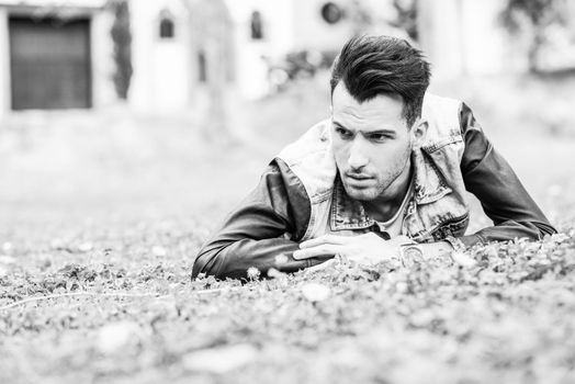 Portrait of a young handsome man, model of fashion, with modern hairstyle in urban background