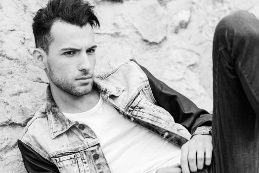 Portrait of a young handsome man, model of fashion, with modern hairstyle in urban background