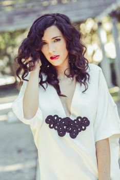 Portrait of beautiful woman, model of fashion, wearing white dress with curly hair