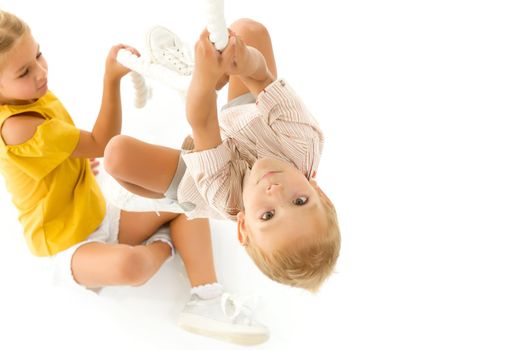 Little girl boy brother, brothers and sisters, climbs through the rope spider web, indoor obstacle quest game. The concept of active play in the home room, quarantine, self-isolation. Isolated on white background.