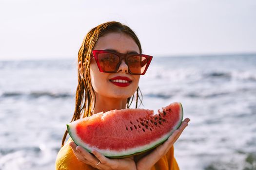 woman on the beach near the ocean eating watermelon. High quality photo