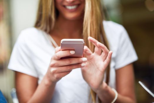 Close-up image of young blonde girl texting with smartphone, female hands typing text message via cellphone, social networking concept